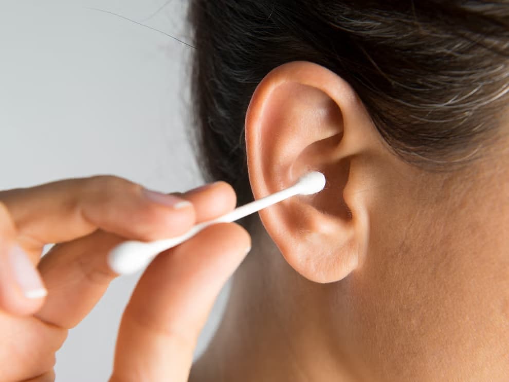 person using a cotton bud to clean ears